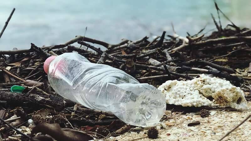 Plastic bottle and polystyrene litter the beach