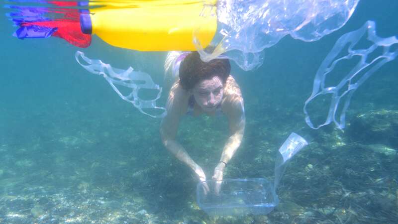 woman swimming in plastic pollution