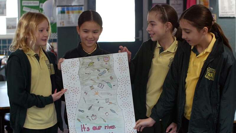 Students from Wattle Grove Public School display their artwork design