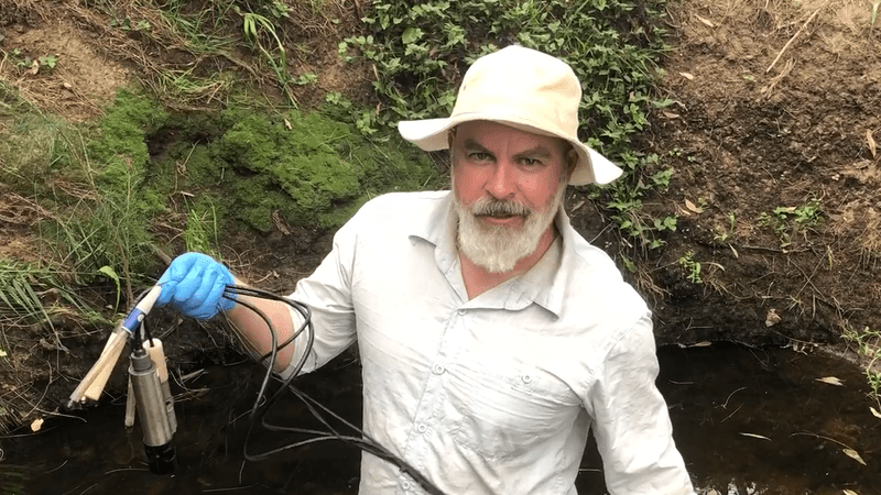 Dr David Reid holding a water quality monitoring device