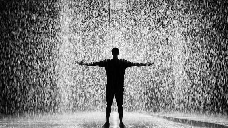 Silhouette of man standing under rainfall